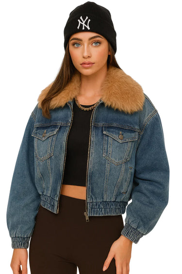 Woman wearing a black beanie with a logo and a blue denim jacket with a fur-lined collar on a white background